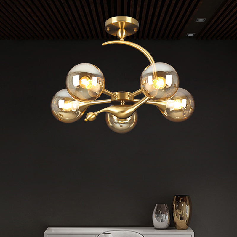Burst Semi Flush Chandelier Postmodern Amber Glass Orb 3/5 Heads Brass Ceiling Mounted Light with Curved Arm over Table Clearhalo 'Ceiling Lights' 'Close To Ceiling Lights' 'Close to ceiling' 'Glass shade' 'Glass' 'Semi-flushmount' Lighting' 1454839