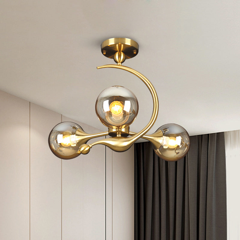 Burst Semi Flush Chandelier Postmodern Amber Glass Orb 3/5 Heads Brass Ceiling Mounted Light with Curved Arm over Table 3 Amber Clearhalo 'Ceiling Lights' 'Close To Ceiling Lights' 'Close to ceiling' 'Glass shade' 'Glass' 'Semi-flushmount' Lighting' 1454842