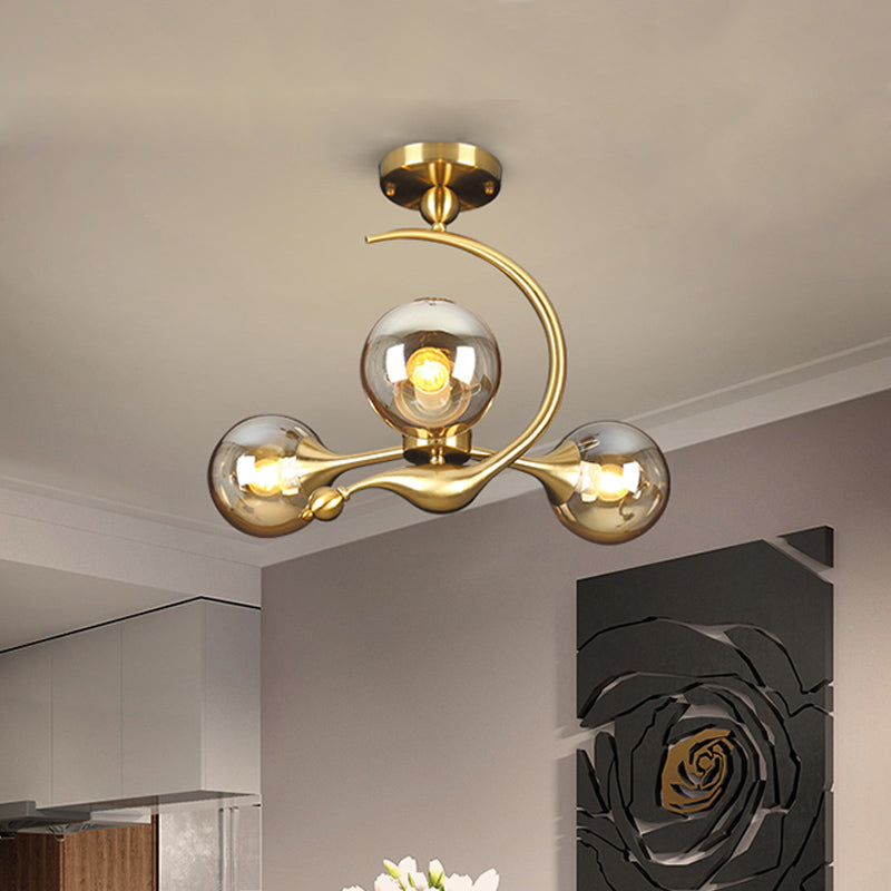 Burst Semi Flush Chandelier Postmodern Amber Glass Orb 3/5 Heads Brass Ceiling Mounted Light with Curved Arm over Table Clearhalo 'Ceiling Lights' 'Close To Ceiling Lights' 'Close to ceiling' 'Glass shade' 'Glass' 'Semi-flushmount' Lighting' 1454844