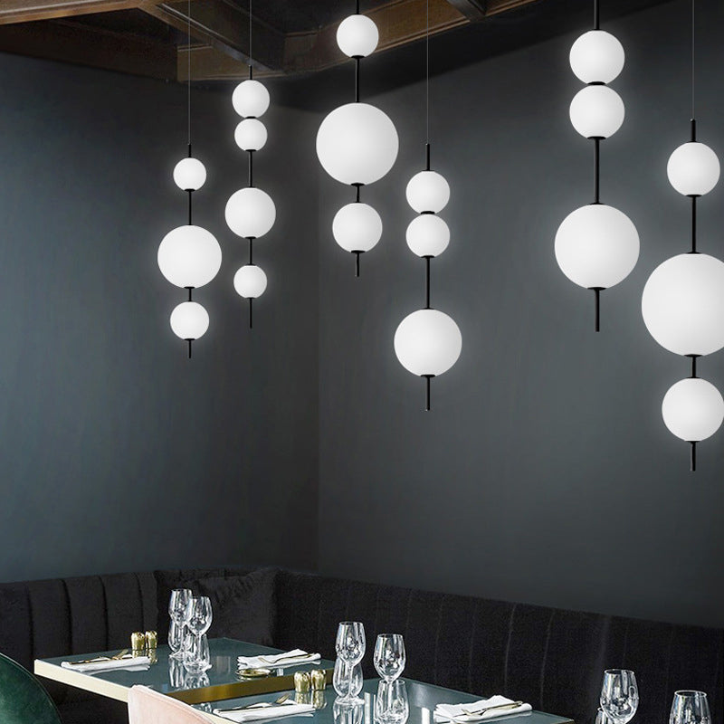 Ball Dining Room Pendulum Light Cream Glass LED Modernity Chandelier Lighting Fixture in Black Clearhalo 'Ceiling Lights' 'Chandeliers' 'Glass shade' 'Glass' 'Modern Chandeliers' 'Modern' Lighting' 2039425