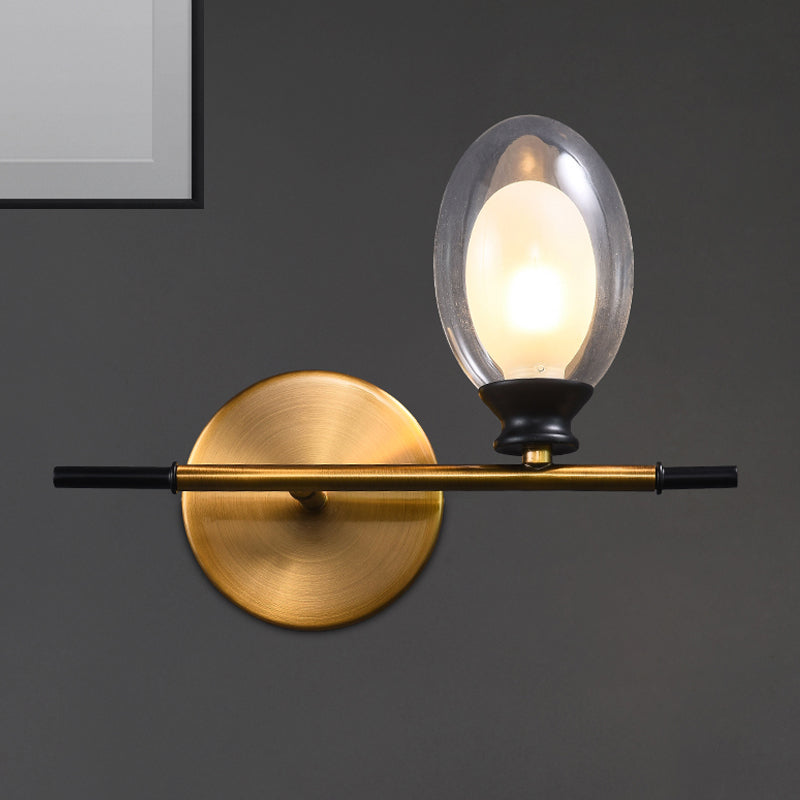 Clear/Amber Glass Egg Shape Wall Light Fixture Minimalist 1 Light Brass Sconce with Horizontal Arm Clear Clearhalo 'Cast Iron' 'Glass' 'Industrial' 'Modern wall lights' 'Modern' 'Tiffany' 'Traditional wall lights' 'Wall Lamps & Sconces' 'Wall Lights' Lighting' 275241