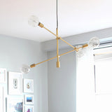 Adjustable Crossed Pendant Lighting Contemporary Metallic 4 Bulbs Gold Chandelier Light with Clear Glass Globe Shade Clearhalo 'Ceiling Lights' 'Chandeliers' 'Modern Chandeliers' 'Modern' Lighting' 295469