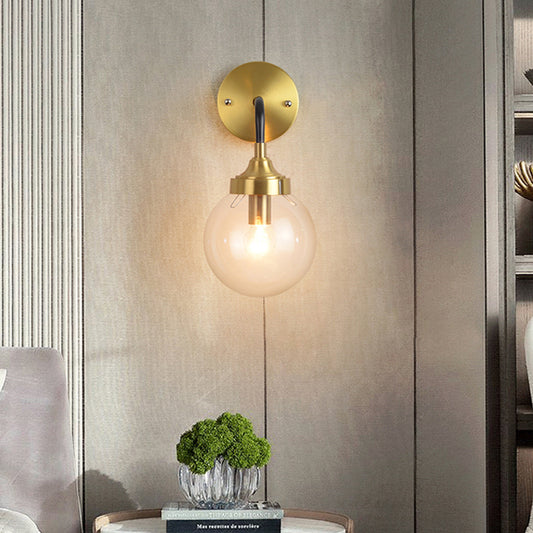 Simple Globe Wall Lighting Clear Glass 1 Bulb Sconce Light Fixture in Brass with Curved Arm Clearhalo 'Cast Iron' 'Glass' 'Industrial' 'Modern wall lights' 'Modern' 'Tiffany' 'Traditional wall lights' 'Wall Lamps & Sconces' 'Wall Lights' Lighting' 331358
