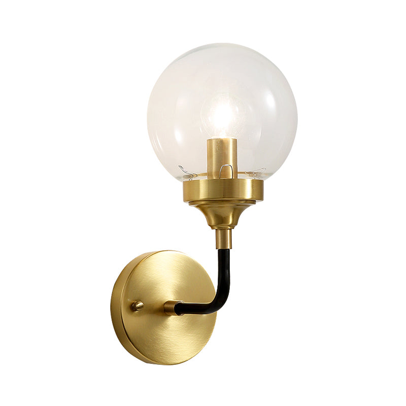 Simple Globe Wall Lighting Clear Glass 1 Bulb Sconce Light Fixture in Brass with Curved Arm Clearhalo 'Cast Iron' 'Glass' 'Industrial' 'Modern wall lights' 'Modern' 'Tiffany' 'Traditional wall lights' 'Wall Lamps & Sconces' 'Wall Lights' Lighting' 331359