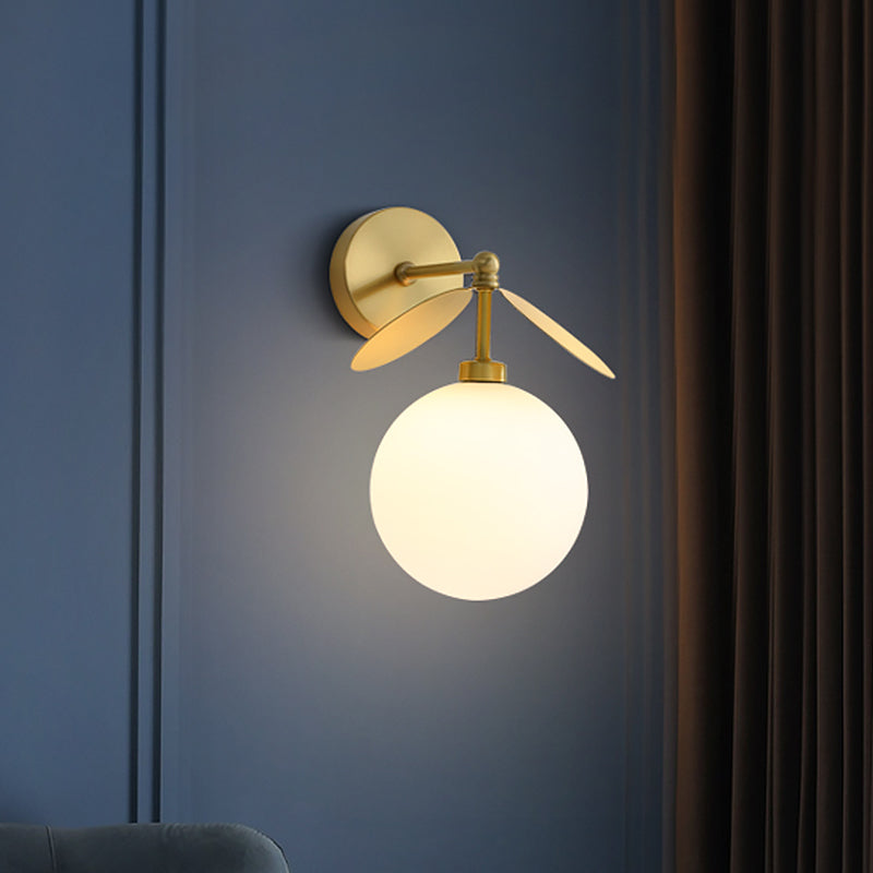 Post Modern Globe/Oval Wall Mount Lamp Cream Glass 1 Light Bedside Wall Light in Brass with Leaf Deco Clearhalo 'Cast Iron' 'Glass' 'Industrial' 'Modern wall lights' 'Modern' 'Tiffany' 'Traditional wall lights' 'Wall Lamps & Sconces' 'Wall Lights' Lighting' 875284